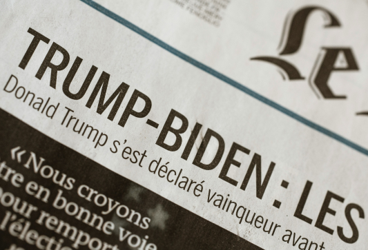 Zoomed in on a piece of French news paper on the header that mentions "TRUMP-BIDEN" 